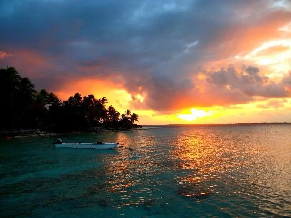 Le lagon de Takapoto au crépuscule, un bateau amarré devant la pension